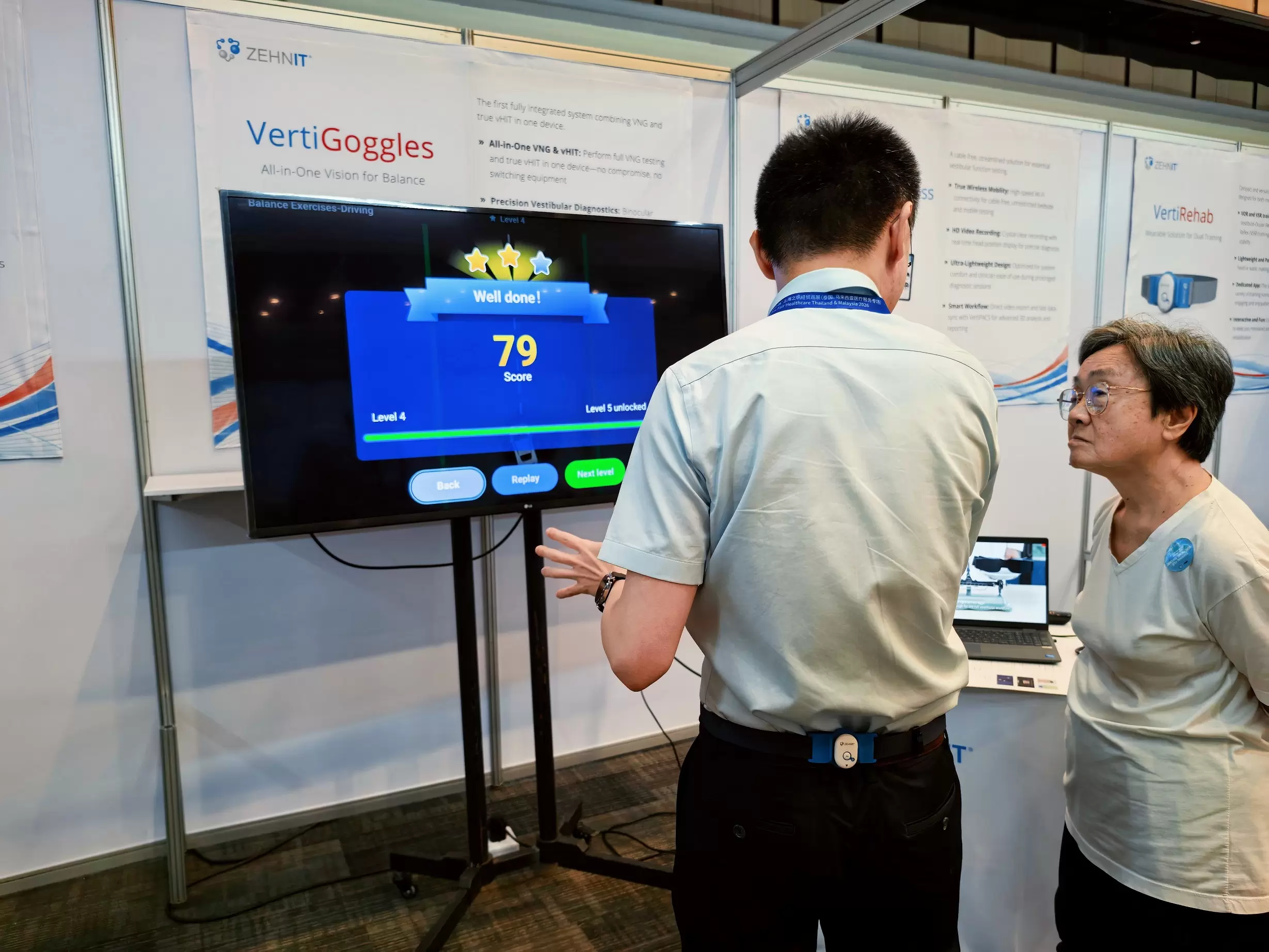 ZEHNIT team demonstrating VertiRehab balance training to a visitor at the exhibition booth. ZEHNIT team demonstrating VertiRehab balance training to a visitor at the exhibition booth.